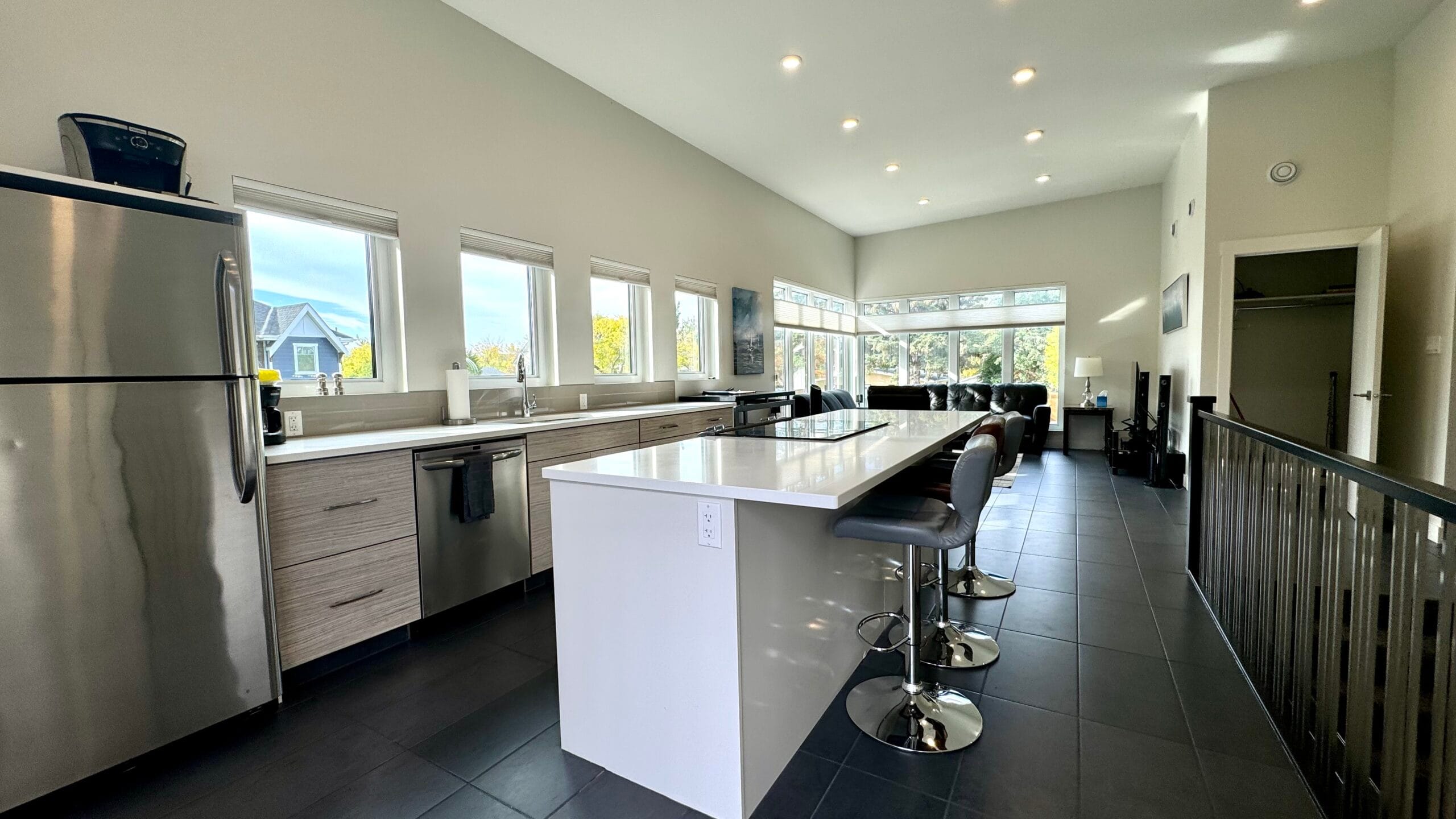 Bright kitchen with windows, stainless steel appliances and charcoal tile floor